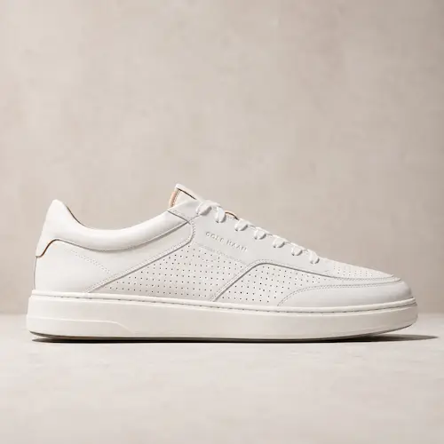 Cole Haan Grand Crosscourt style white perforated sneakers for men shown as smart casual shoes for chinos and casual office outfits
